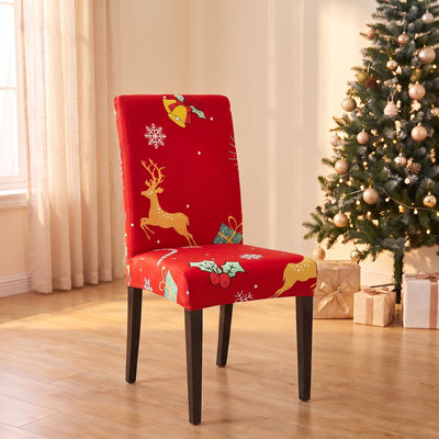 Jingle Reindeer Christmas stretch chair cover on a dining chair by the Christmas tree
